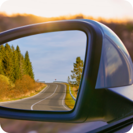 Gros plan sur le rétrovisuer lors d'un départ de véhicule, illustrant les erreurs de contrôle et d'observation avant de démarrer avec l'auto-école Hello Permis.